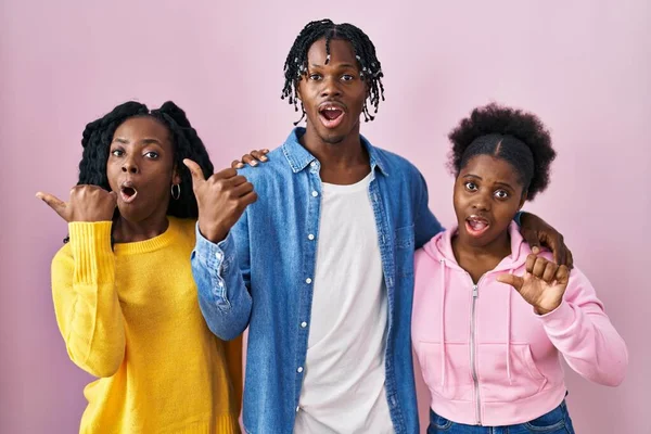 Grupo Três Jovens Negros Juntos Sobre Fundo Rosa Surpreso Apontando — Fotografia de Stock