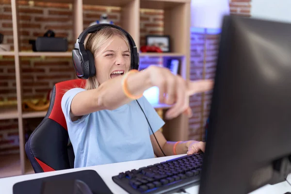 Young Caucasian Woman Playing Video Games Wearing Headphones Pointing Displeased — Stock Photo, Image