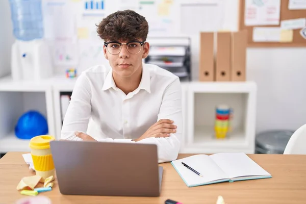 stock image Young hispanic teenager business worker smiling confident sitting with arms crossed gesture at office