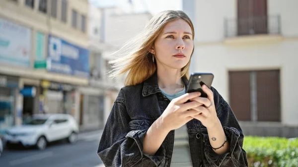 Νεαρή Ξανθιά Γυναίκα Που Χρησιμοποιεί Smartphone Σοβαρό Πρόσωπο Στο Δρόμο — Φωτογραφία Αρχείου