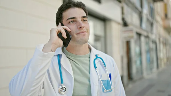 年轻的惊慌失措的医生在医院用智能手机自信地微笑着 — 图库照片