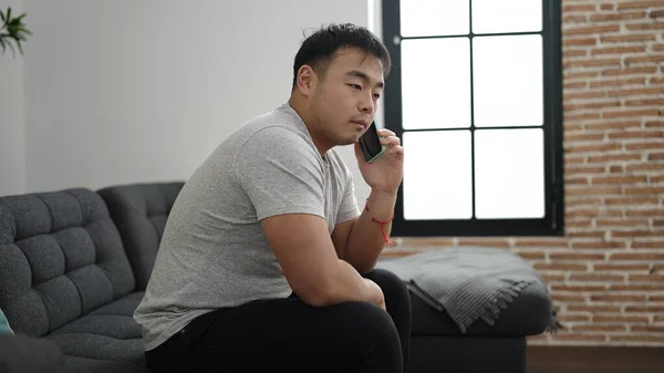 Mladý Číňan Mluví Smartphone Sedí Pohovce Doma — Stock fotografie