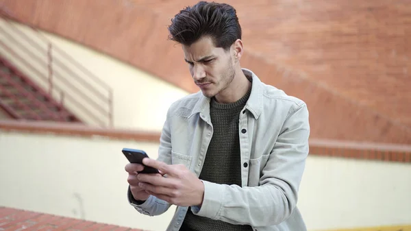 Junger Hispanischer Mann Benutzt Smartphone Mit Ernstem Gesichtsausdruck Auf Der — Stockfoto