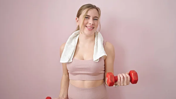 Junge Blonde Frau Trägt Sportkleidung Mit Kurzhanteln Vor Isoliertem Rosa — Stockfoto