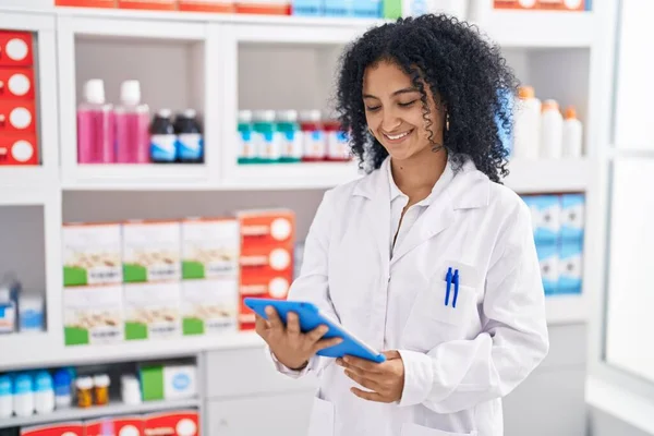 Young Hispanic Woman Pharmacist Smiling Confident Using Touchpad Pharmacy — Stockfoto