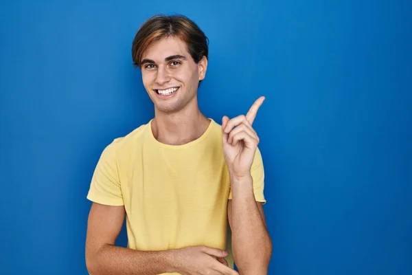 Mavi Arka Planda Duran Genç Adam Yüzünde Kocaman Bir Gülümsemeyle — Stok fotoğraf