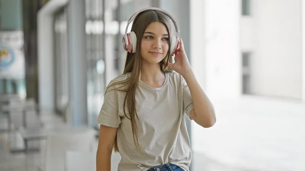 Νεαρό Όμορφο Κορίτσι Που Ακούει Μουσική Στέκεται Στη Βιβλιοθήκη — Φωτογραφία Αρχείου