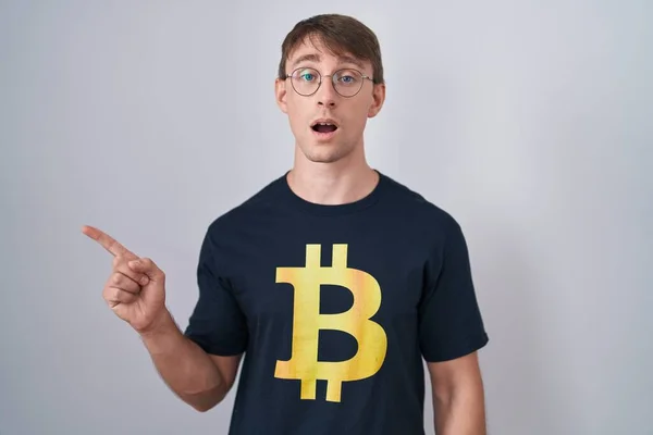 Biały Blondynka Człowiek Bitcoin Koszulka Zaskoczony Wskazując Palcem Bok Otwartymi — Zdjęcie stockowe