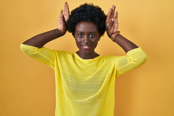 Afrykańska Młoda Kobieta Stojąca Nad Żółtym Studiem Wykonująca Gesty Króliczych — Zdjęcie stockowe