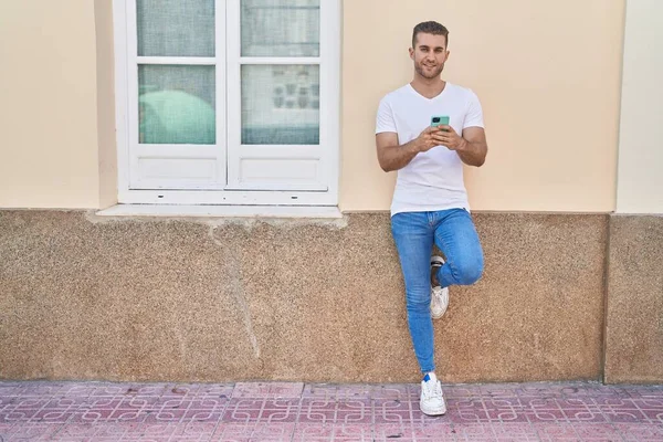 Stock image Young caucasian man smiling confident using smartphone at street