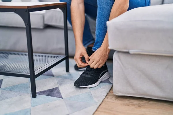 Jovem Árabe Homem Amarrando Sapato Sentado Sofá Casa — Fotografia de Stock