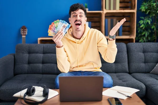 Hombre Hispano Trabajando Con Laptop Sosteniendo Billetes Francos Suizos Celebrando — Foto de Stock
