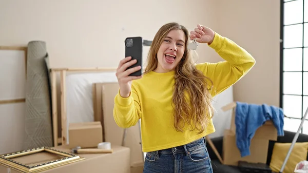 Young Blonde Woman Having Video Call Holding Key New Home — Zdjęcie stockowe