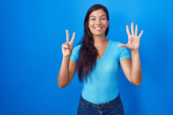 Mladá Hispánka Stojící Nad Modrým Pozadím Ukazující Ukazující Prsty Číslo — Stock fotografie