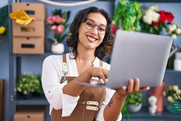 Young Beautiful Hispanic Woman Florist Smiling Confident Using Laptop Flower — Stockfoto