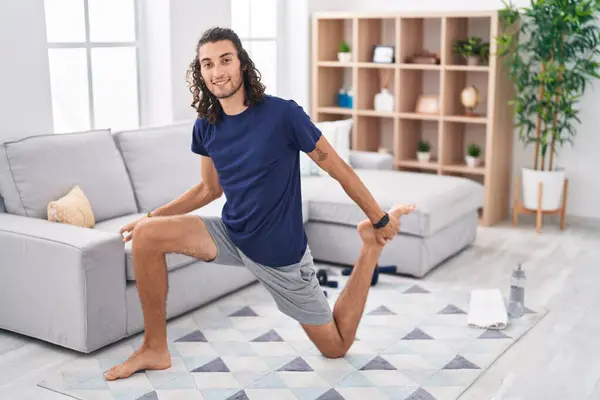 Young Hispanic Man Stretching Leg Sitting Floor Home — Foto de Stock