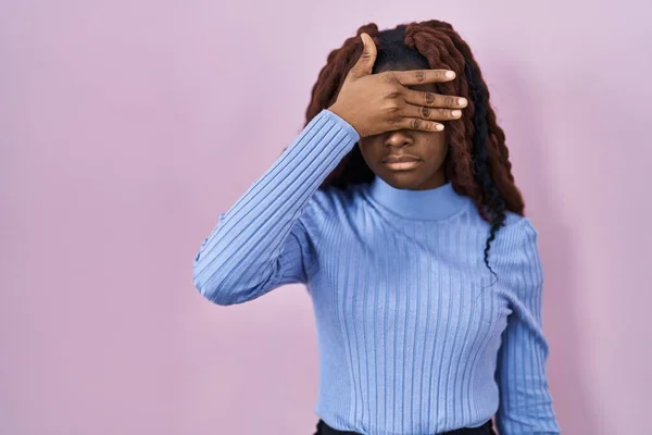Африканская Женщина Стоящая Розовом Фоне Закрывая Глаза Рукой Выглядит Серьезной — стоковое фото