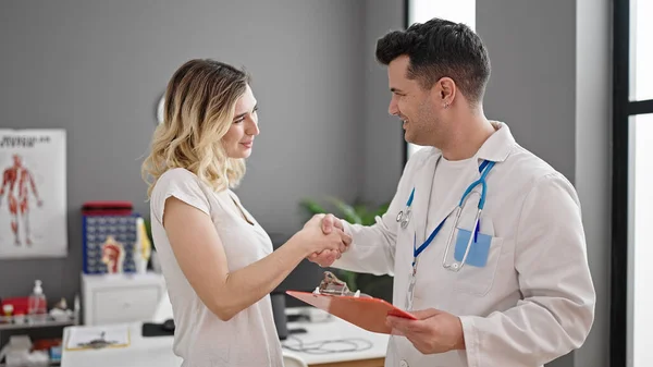 診療所で握手をする男女の医師と患者 — ストック写真