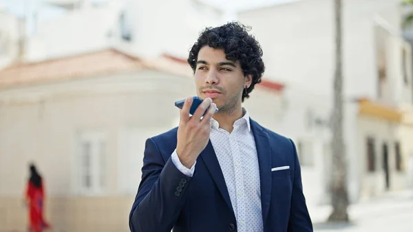 年轻的拉丁商人在街上用智能手机发送语音讯息 — 图库照片