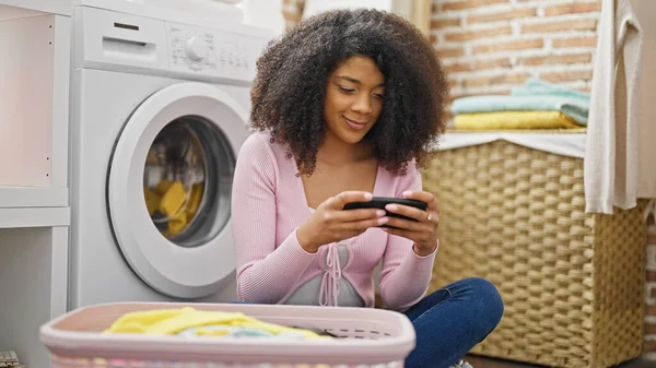 Africano Mulher Americana Assistindo Vídeo Smartphone Espera Máquina Lavar Roupa — Fotografia de Stock