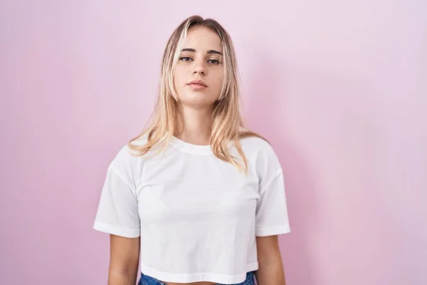 Young Blonde Woman Standing Pink Background Relaxed Serious Expression Face — Stockfoto