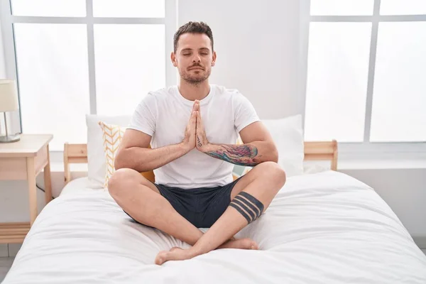 Young Hispanic Man Doing Yoga Exercise Sitting Bed Bedroom — Stockfoto
