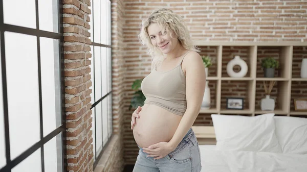 若いです妊娠中の女性タッチ腹立ってベッドルーム — ストック写真