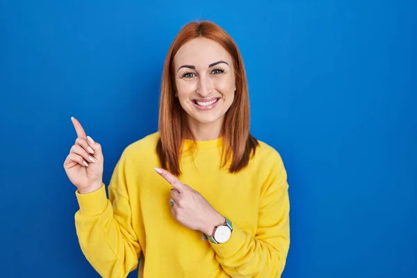 Young Woman Standing Blue Background Smiling Looking Camera Pointing Two — 图库照片
