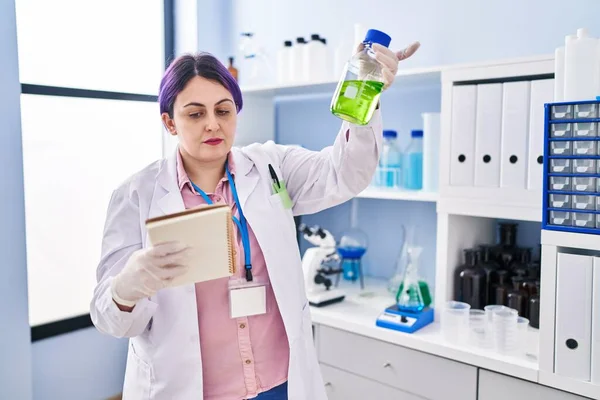 Young Beautiful Size Woman Scientist Reading Notebook Holding Bottle Liquid — 스톡 사진
