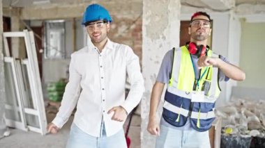 İnşaat alanında kendine güvenen iki adam mimar ve mimar gülümsüyor.