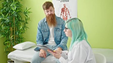 Kadın ve erkek doktor ve hasta klinikte tıbbi raporları okuyorlar.