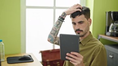 Genç İspanyol iş adamı ofiste gülümseyen bir dokunmatik kağıt ile selfie çekiyor.