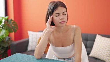 Masada oturan genç, güzel İspanyol kadın yemek odasında üzgün üzgün bakıyor.