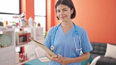 Genç, güzel İspanyol kadın elinde yemek odasında gülümseyen bir belge tutuyor.