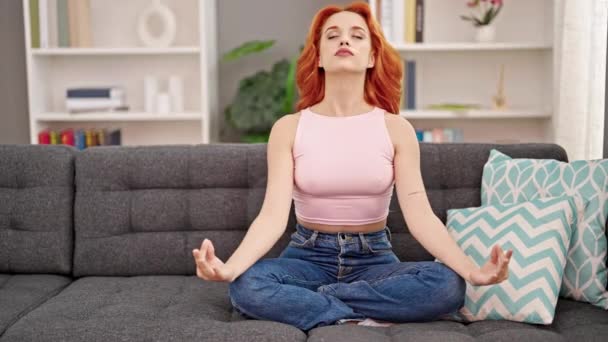 Junge Rothaarige Frau Macht Yoga Übungen Sitzend Auf Dem Sofa — Stockvideo