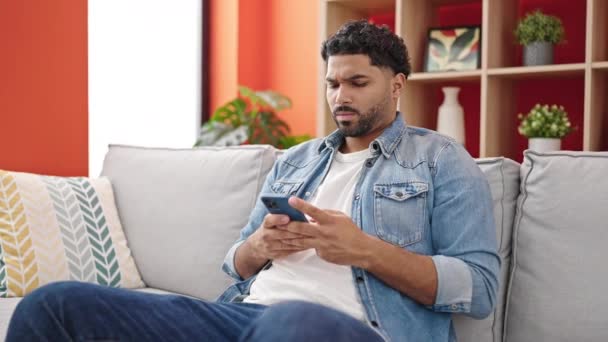 Αφροαμερικανός Άνδρας Που Χρησιμοποιεί Smartphone Κάθεται Στον Καναπέ Δυστυχισμένη Έκφραση — Αρχείο Βίντεο