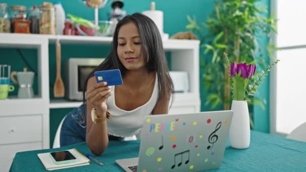 アフリカ系アメリカ人女性のショッピングノートパソコンとクレジットカードのテーブルの上にダイニングルームに座って — ストック動画