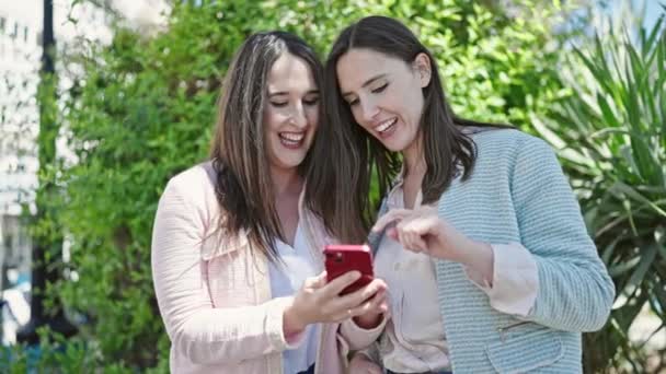 Dwie Kobiety Uśmiechnięte Pewnie Pomocą Smartfona Parku — Wideo stockowe