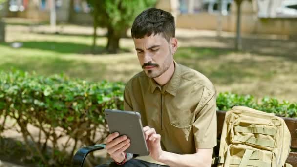 Young Hispanic Man Tourist Using Touchpad Sitting Bench Park — Stock Video