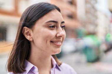 Sokakta kendine gülen genç İspanyol kadın.