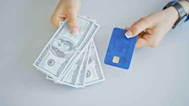 Ofiste dolar ve kredi kartı tutan genç sarışın kadın.