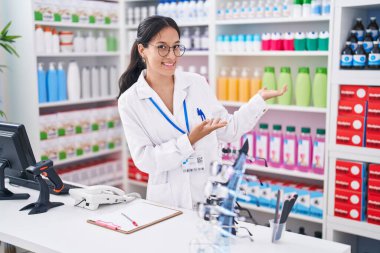Eczanede çalışırken gülümseyen güzel İspanyol kadın eczacı.