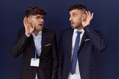 İki İspanyol iş adamı iş kıyafetleri giyip el pençe divan gülüyor. Dedikoduları ve dedikoduları dinliyorlar. Sağırlık kavramı. 