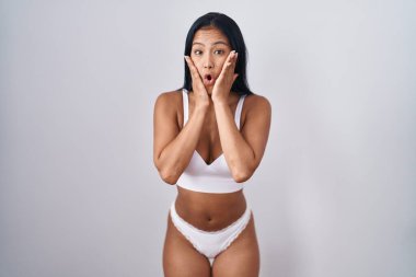 İspanyol kadın iç çamaşırı giyiyor. Korkmuş ve şok olmuş. Şaşırmış ve şaşırmış. 