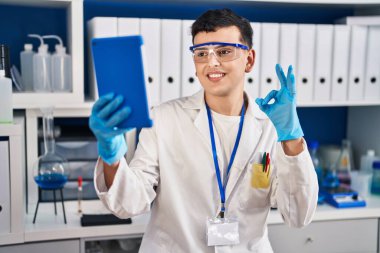 Bilim adamlarının laboratuvarında çalışan, tablet kullanan, parmaklarıyla imza atan, gülümseyen, dostça hareketler yapan, mükemmel bir sembol. 