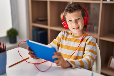 Blond child playig video game using smartphone at home