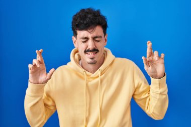 Mavi arka planda dikilen İspanyol adam umut ve gözlerin kapalı bir şekilde gülümseyerek bana işaret etti. Şans ve batıl inançlar. 