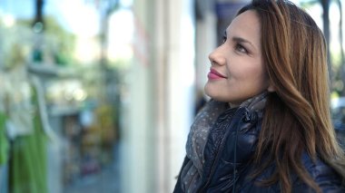 Young beautiful hispanic woman smiling confident looking to the side at street