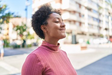 African american woman breathing with closed eyes at street