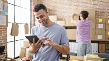 Ofiste çalışan iki işçi touchpad kullanıyor.